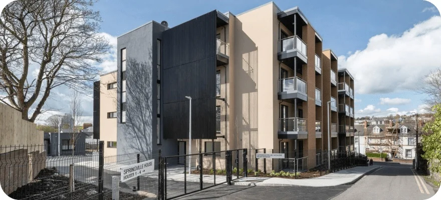 Modern apartment building with balconies and trees.
