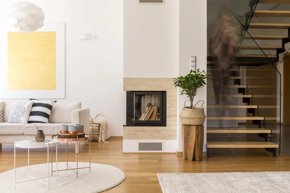 Modern living room with fireplace and large windows.